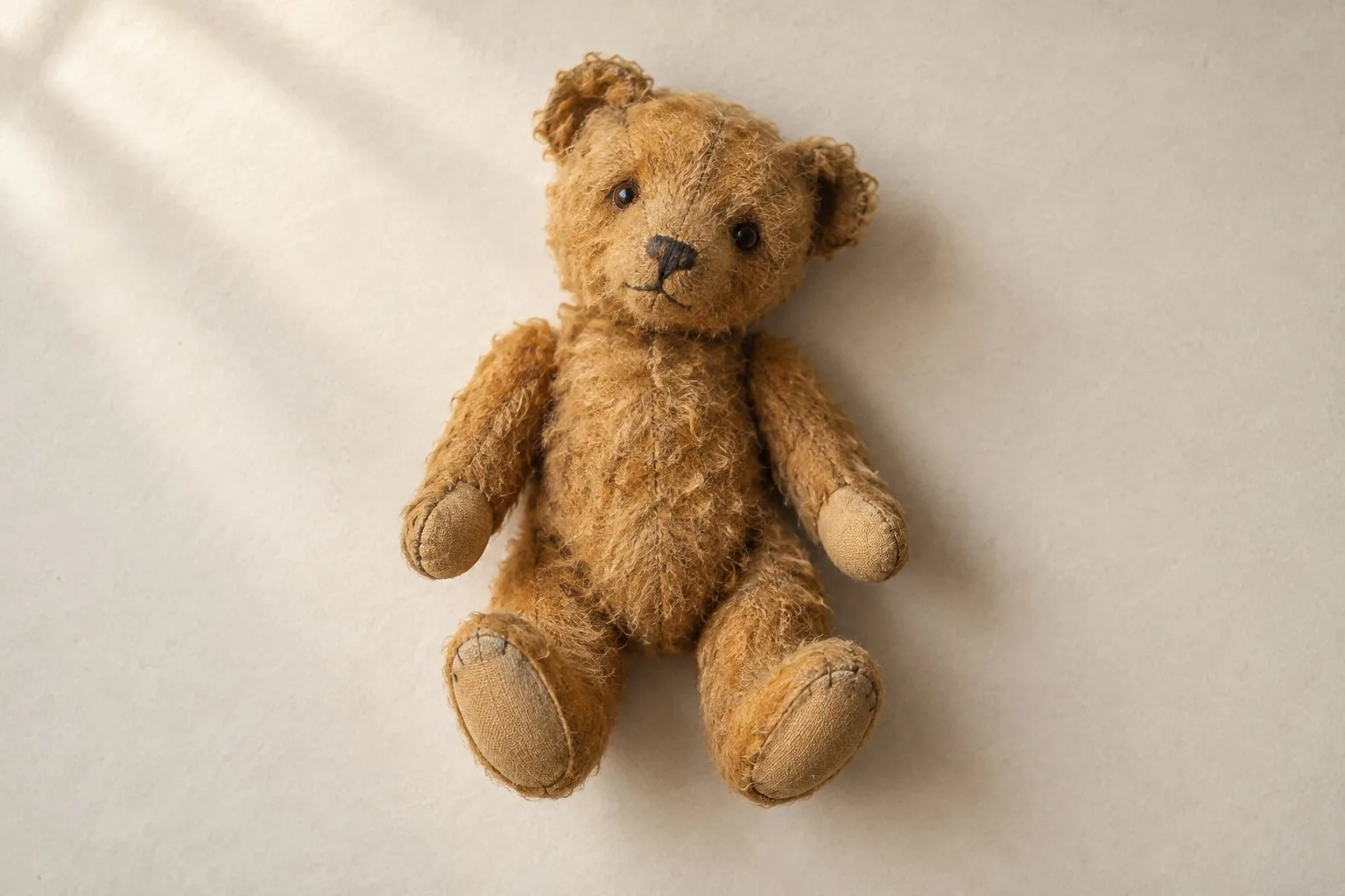 Un petit ours en peluche ancien au pelage couleur miel
