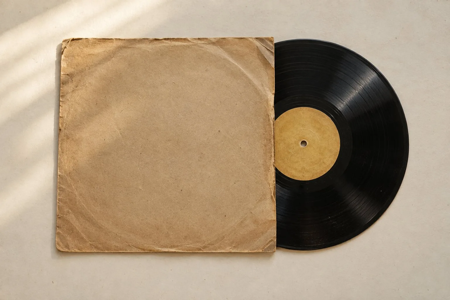 Un disque vinyle noir à étiquette ocre sortant d’une pochette en papier kraft
